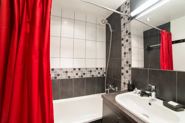 Modern bathroom with sink and red curtains — Stock Photo, Image