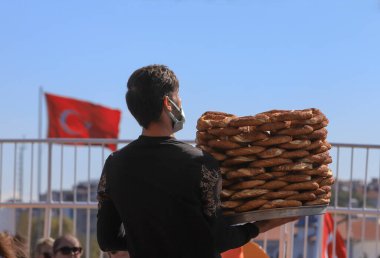 İSTANBUL, Türkiye - 05 Ekim 2021. Adalar feribotunda simit satıcısı. Geleneksel Türk hamur işi satıcısı.