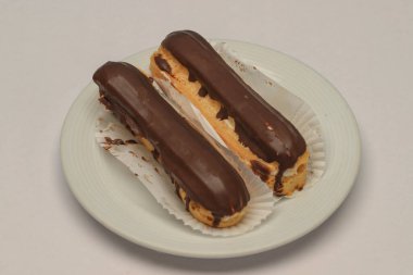 Beyaz arka planda izole edilmiş çikolatalı pasta. Profiterol ya da eclair kapatılıyor