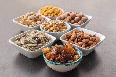 Seçici odak noktasında tohumsuz üzümler. Kurutulmuş dut, fındık, şam fıstığı, sarı nohut, şam fıstığı, badem ve ay çekirdeği..