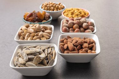 Seçici odak noktasında ayçiçeği. Kurutulmuş dut, fındık, fıstık, fıstık, üzüm, badem, kabuklu sarı nohut ve fıstık arkaplanı.