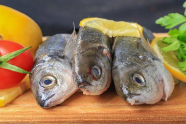 Taze Yakalanmış Bogue Balığı veya Boops Balığı ahşap kesim tahtasıyla pişirilmeye hazır: Türk adı Kupes Fish