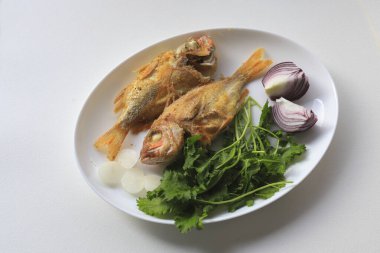 Beyaz arka plan. Tabakta kızarmış mercan balığı.