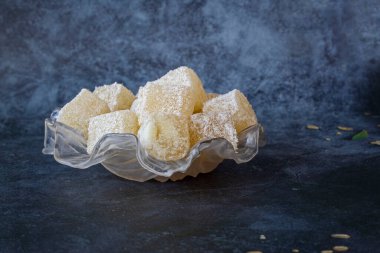 Beyaz cam bir tabakta hindistan ceviziyle kaplı tatlı Türk lokumu. .