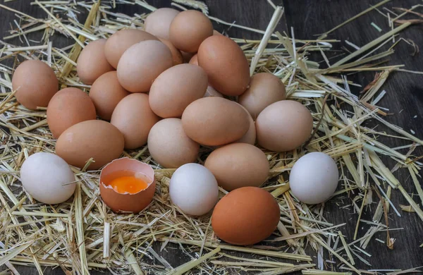Stack of egg on straw with wooden table background.Top view.