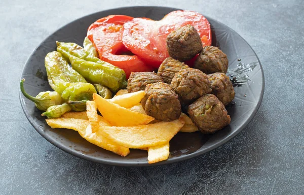 Vegetable patties for vegan burgers in plate, gray marble background.