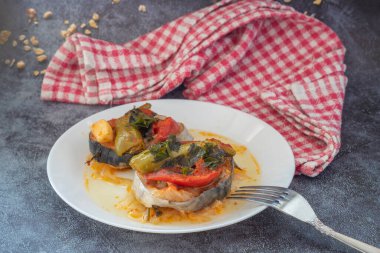 Lezzetli geleneksel Türk balığı yemeği, Palamut Pilaki. Beyaz tabakta büyük bir balık tabağının sunumu. Üst çekim.