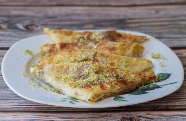 Geleneksel Türk Tatlısı Katmer, pıhtılaşmış krema, hamur ve Gaziantep bölgesinin katmerli tatlısı. İnce hamurlu tatlı ile hazırlanmış yeşil şam fıstığı.