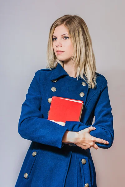 Joven chica hermosa sosteniendo el libro rojo — Foto de Stock