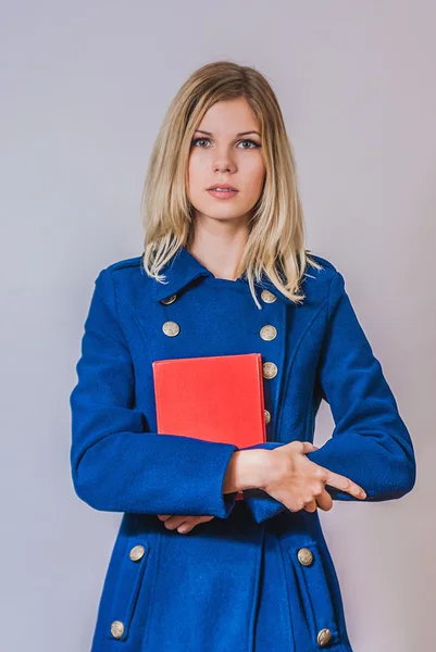 Joven chica hermosa sosteniendo el libro rojo — Foto de Stock