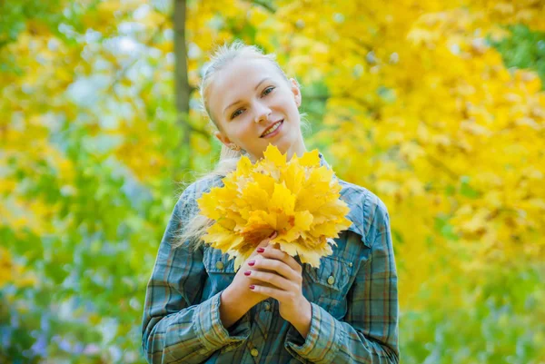 Junge Frau mit Herbstblättern — Stockfoto