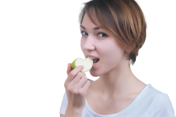 Ganska ung flicka med bit av grönt äpple — Stockfoto