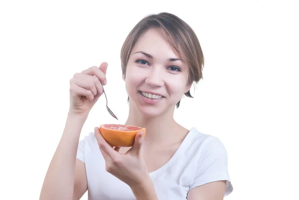 Girl eating grapefruit by the spoon — Stock Photo, Image