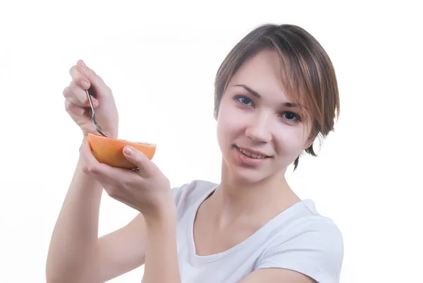 Girl eating grapefruit by the spoon — Stock Photo, Image