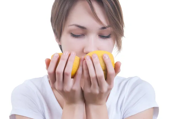 Mädchen schnüffelt an zwei Teilen Zitrone — Stockfoto