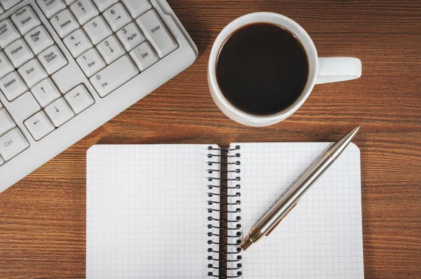 Bloc de notas en blanco, teclado, pluma y taza de café —  Fotos de Stock