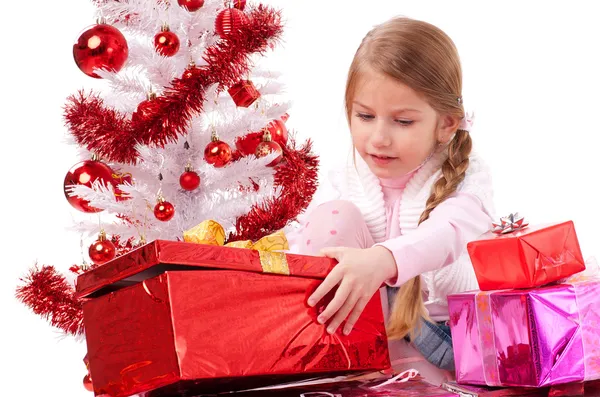 Menina com presentes de Natal perto de uma árvore de Natal artificial branca — Fotografia de Stock