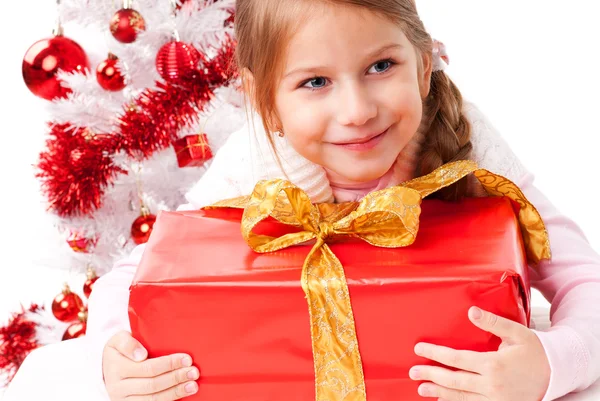 Glad liten flicka med julklappar nära en vit konstgjord julgran — Stockfoto