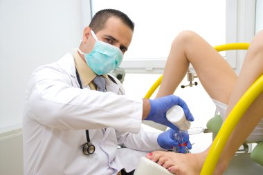 bir pelvik muayene sırasında doktor