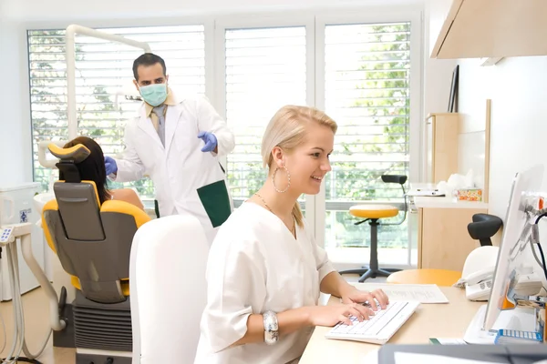 Examen dental, mientras el asistente está trabajando en una computadora portátil —  Fotos de Stock