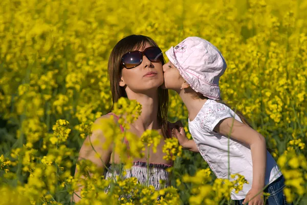 Tânăra mamă și fiica ei se distrează pe câmpul colza — Fotografie, imagine de stoc