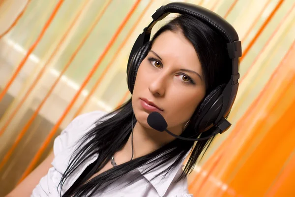 Mädchen sitzt an einem Tisch mit Kopfhörern — Stockfoto