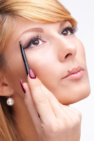 Beautiful young woman applying eyeshadow powder — Stock Photo, Image