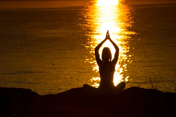 Silhuett av en kvinna som gör yoga — Stockfoto