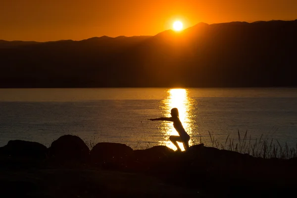 Silueta de una mujer haciendo yoga — Foto de Stock