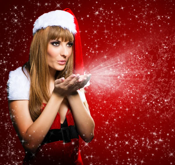 Yıldız kırmızı zemin üzerine üfleme genç bir Noel Baba kız portresi — Stok fotoğraf