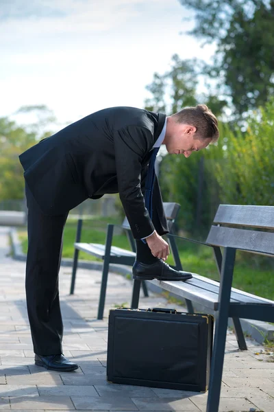 El hombre de negocios se ata el cordón. — Foto de Stock