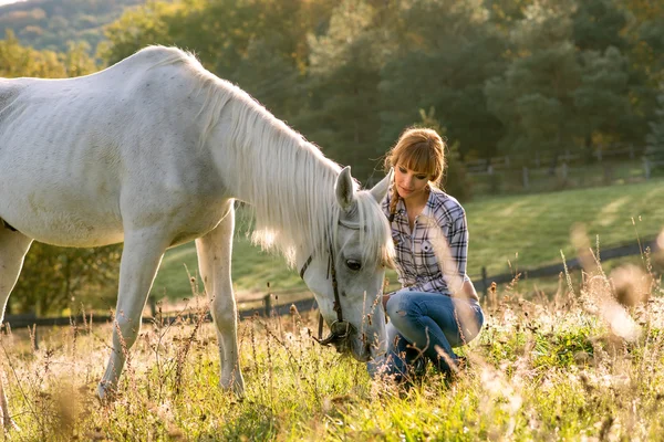 Mujer con un caballo blanco — Foto de Stock