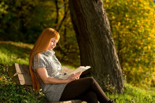 Frau las Buch im Herbstwald — Stockfoto