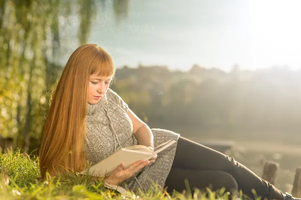 Frau liest am See — Stockfoto