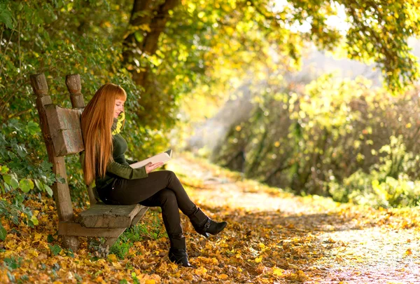 Žena čte v podzimní přírodě — Stock fotografie