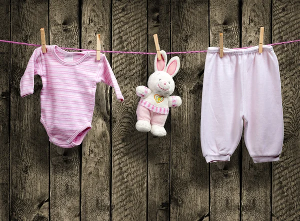 Baby girl oblečení a bunny na prádelní šňůře — Stock fotografie