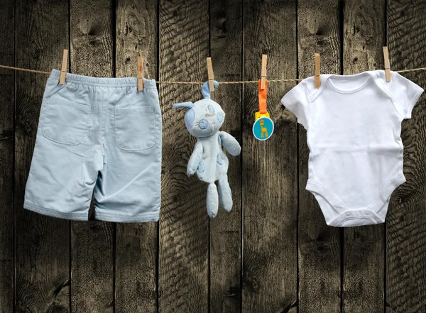 Bebé niño ropa y conejito de peluche en un tendedero —  Fotos de Stock