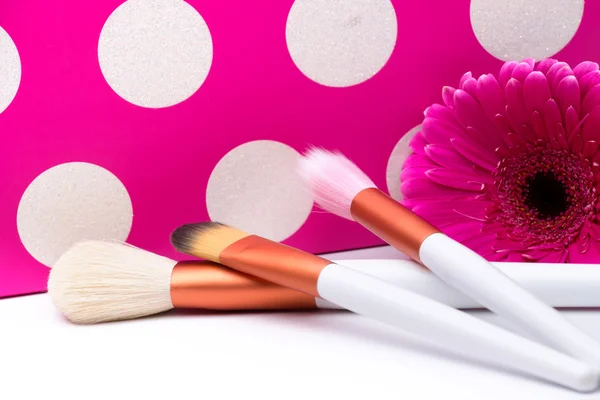 Pincéis de maquiagem em bolinhas fundo rosa — Fotografia de Stock