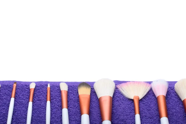 Makeup Brushes set on purple towel — Stock Photo, Image