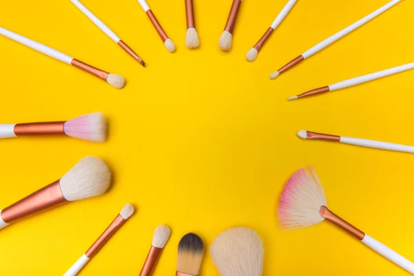 Cepillos de maquillaje círculo sobre fondo amarillo — Foto de Stock