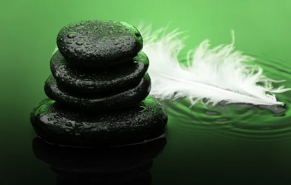 Massage stones with feather and water drops — Stock Photo, Image