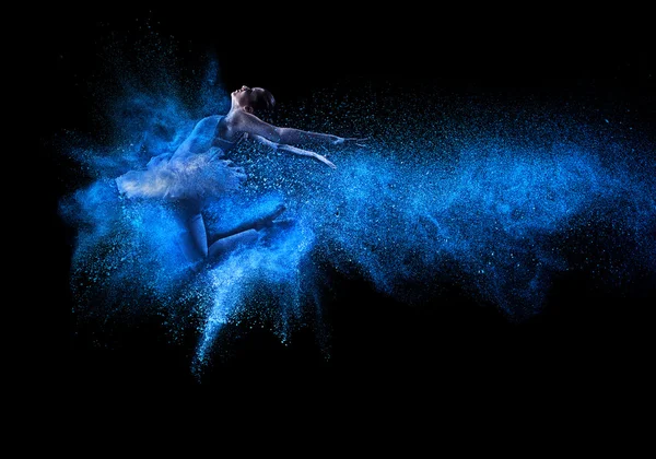 Jonge mooie danseres springen in blauw poeder wolk — Stockfoto