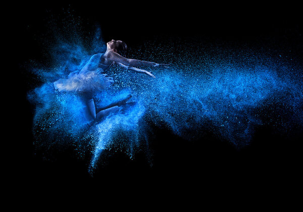 Молодая красивая танцовщица прыгает в голубое облако
