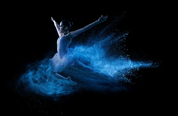 Young beautiful dancer jumping into blue powder cloud — Stock Photo, Image