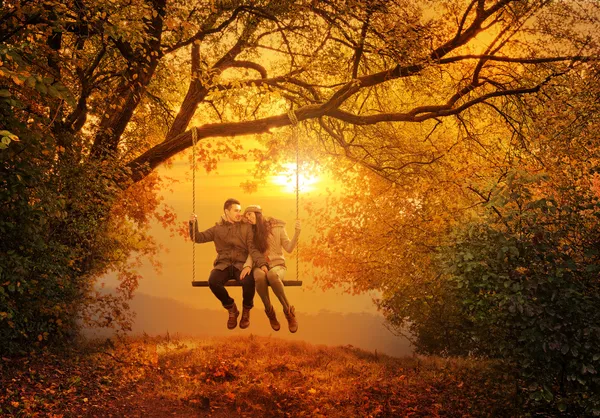 Romantic couple swing in the autumn park — Stock Photo, Image