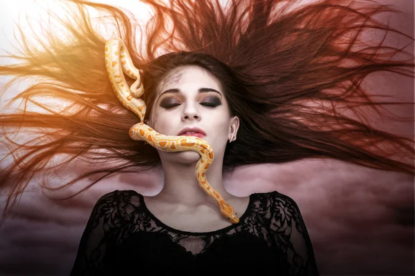 Mulher deitada no chão com os olhos fechados, de frente para a cobra slither-awesome — Fotografia de Stock