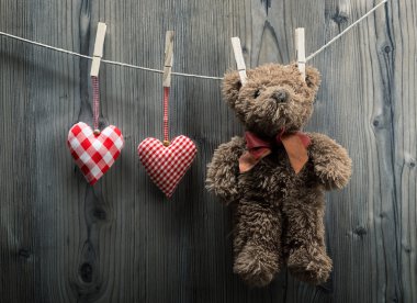 Sevgililer günü duvar kağıdı - Tekstil kalpleri ile asılı bir oyuncak ayı