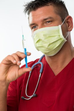 ağız maskesi, stetoskop ve şırınga ile yakışıklı genç bir doktor