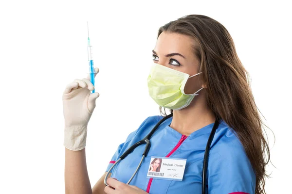 Jovem enfermeira bonita na boca máscara e seringa — Fotografia de Stock