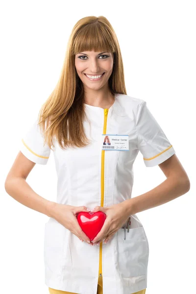 Hermosa enfermera sosteniendo corazón rojo — Foto de Stock